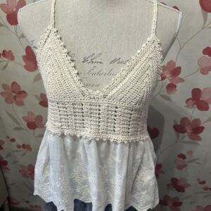Top de crochet color crudo con escote en pico, tirantes finos y volante de algodón bordado, ideal para looks boho y románticos de verano.