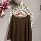 Jersey de mujer marrón chocolate de punto con cuello redondo y ribetes en color crudo.