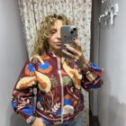 Chaqueta de mujer burdeos con estampado floral multicolor, cremallera frontal y mangas abullonadas.