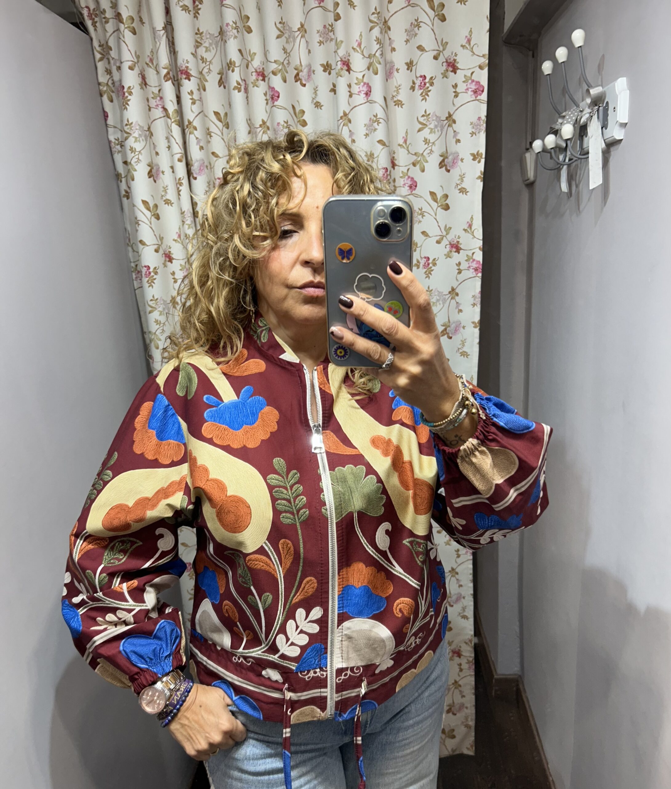 Chaqueta de mujer burdeos con estampado floral multicolor, cremallera frontal y mangas abullonadas.