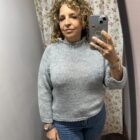 Jersey de mujer de punto grueso color gris claro con cuello vuelto y mangas largas.