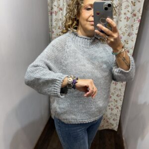 Jersey de mujer de punto grueso color gris claro con cuello vuelto y mangas largas.