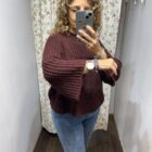 Jersey de punto color berenjena con mangas anchas y cuello redondo combinado con vaqueros.
