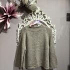 Jersey de mujer de punto grueso color gris claro con cuello vuelto y mangas largas.