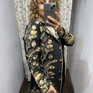Abrigo negro con bordados florales dorados, botones delanteros y ribetes decorativos