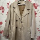 Chaquetón oversize de antelina beige con solapas, doble botonadura y bolsillos laterales.
