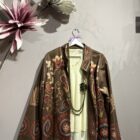 Chaqueta boho marrón con estampado floral y motivos ornamentales en tonos teja, granate y beige.