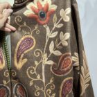 Chaqueta boho marrón con estampado floral y motivos ornamentales en tonos teja, granate y beige.