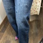 Vaquero azul de corte recto con pequeñas rosas bordadas y detalles brillantes.