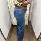 Vaquero azul de corte recto con pequeñas rosas bordadas y detalles brillantes.