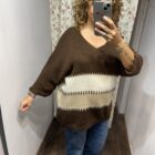 Jersey oversize marrón chocolate con rayas en tonos crudo y beige, escote en pico y manga amplia.