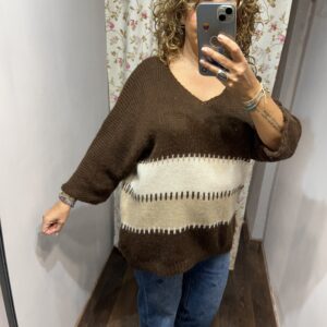 Jersey oversize marrón chocolate con rayas en tonos crudo y beige, escote en pico y manga amplia.