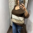 Jersey oversize marrón chocolate con rayas en tonos crudo y beige, escote en pico y manga amplia.