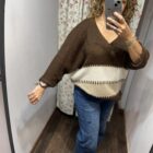 Jersey oversize marrón chocolate con rayas en tonos crudo y beige, escote en pico y manga amplia.