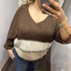 Jersey oversize marrón chocolate con rayas en tonos crudo y beige, escote en pico y manga amplia.
