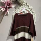 Jersey oversize marrón chocolate con rayas en tonos crudo y beige, escote en pico y manga amplia.