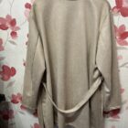 Chaquetón oversize de antelina beige con solapas, doble botonadura y bolsillos laterales.