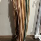 Vista lateral del pantalón de rayas verticales multicolor con tejido de efecto terciopelo y pernera ancha