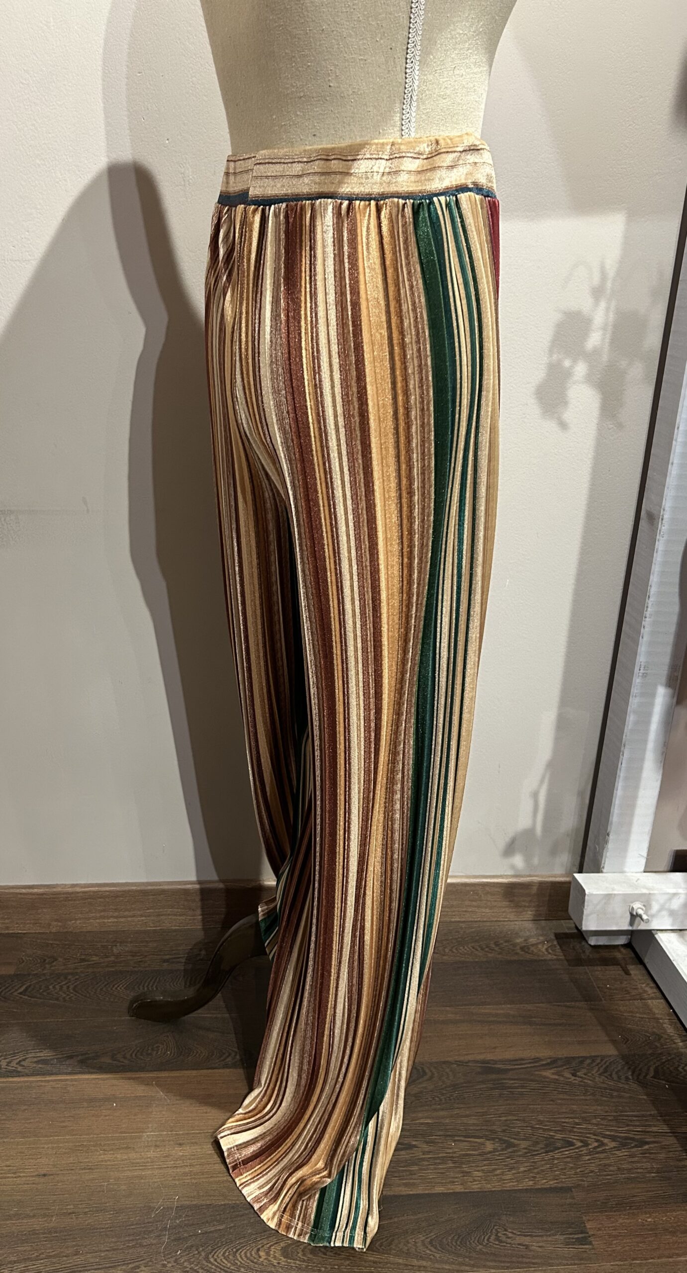 Vista lateral del pantalón de rayas verticales multicolor con tejido de efecto terciopelo y pernera ancha