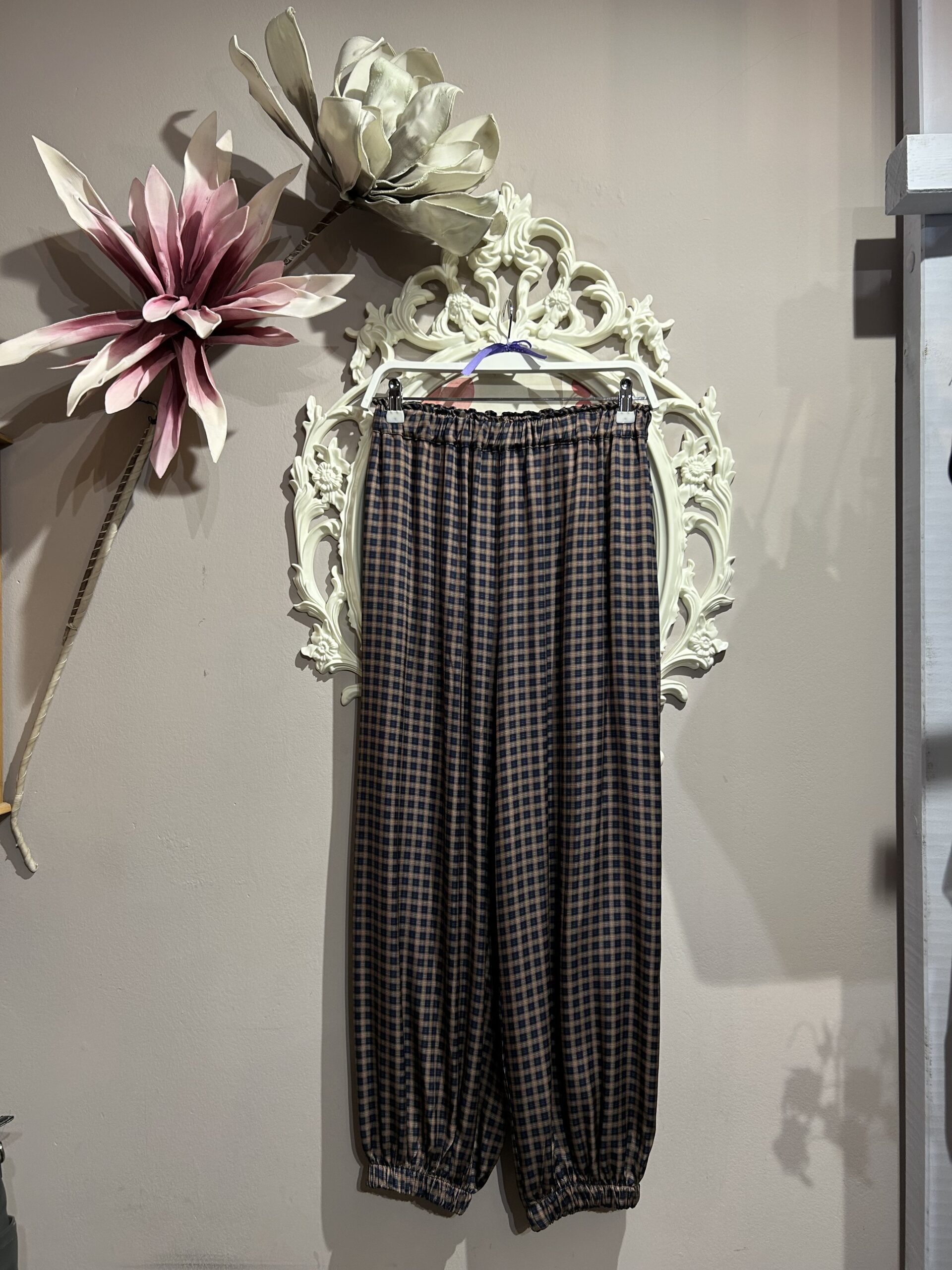 Pantalón jogger de mujer con estampado de cuadros azul marino y camel y bajos elásticos.