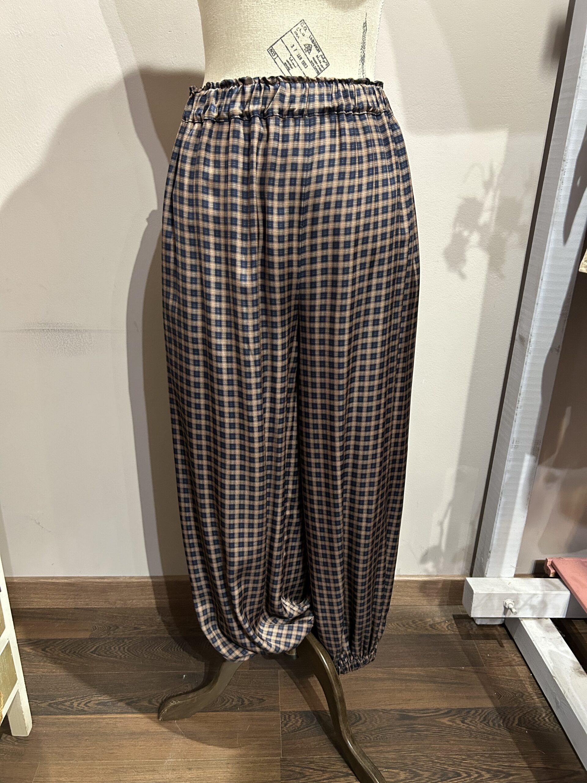 Pantalón jogger de mujer con estampado de cuadros azul marino y camel y bajos elásticos.