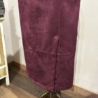 Detalle de la falda granate efecto ante con costuras decorativas.